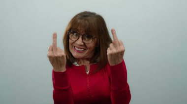 Kırmızı tişörtlü İspanyol son sınıf öğrencisi kadın beyaz arka planda orta parmaklı ve neşeli bir ifade sergiliyor..