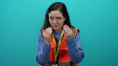 Mavi arka plana karşı gönüllü yeleği giyen sessiz ve gönüllü bir kadın.