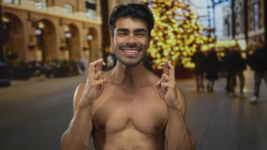 Parlak ışıkların altında kalabalık bir şehir sokağında göğsü açık genç İspanyol adam şans diliyor..