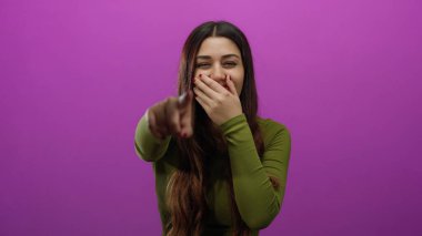 İzole edilmiş pembe arka planda gülen ve işaret eden bir kadın, gençlik neşesi ve neşeli bir ifade sergiliyor, İspanyol kimliğini ve canlı atmosferi vurguluyor..