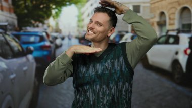 Arka planda arabaları olan, şehir atmosferinde mutluluk ve canlılık gösteren, neşeli hareketler yapan genç bir adam..