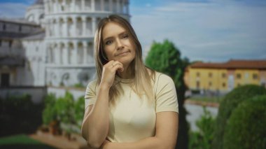 Güneşli bir günde güneşli bir arka planda sidikli, italyan, gösterişli seyahat, mimari ve tefekkür kulesinin önünde düşünen kadın..