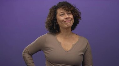 Stüdyoda parmak uçlarında hafif bir sırıtışla başparmak ve el hareketlerini sergileyen kadın, onaylandı..