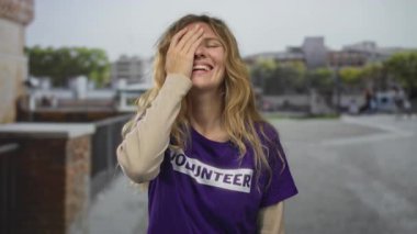 Şehir gönüllü ortamında el kaplaması ifadesi olan kadın profili, açık hava perspektifinde gülümseyen sarışın genç kadın profili.