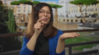 Gülümseyen ve parmaklarıyla eski Roma binasını işaret eden kadın, açıklığı hoş karşılıyor..