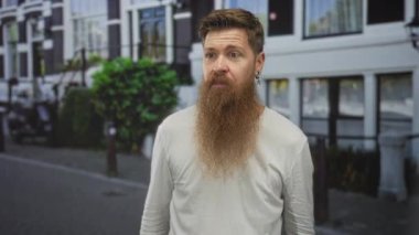 Kalın kırmızı sakallı adam, şehir caddesinde ağzı açık, tamam işareti için göz göze gelir..