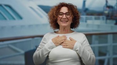 Teknedeki kadın, kendisine doğru hareket ederken şaşkınlığını ifade eder. Arkasındaki deniz kenarında neşeli bir anı yakalar..