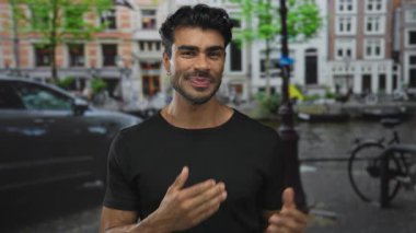 İki eliyle hareket eden adam yoğun şehir caddesinde park halindeki bisikleti işaret ediyor. Keşif merakı keşif yolculuğu..