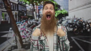 Renkli kiralık bisiklet parkının önünde yumruk sallayan ve bağıran adam gündüz vakti sokakta; heyecan.