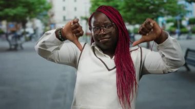 Woman expressing disapproval outdoors on a city street with trees and buildings in the background, showcasing urban life and emotion.