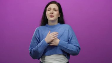 Mavi kazaklı kadın pembe arka planda çeşitli duygular gösteriyor. Stüdyo ortamında korku ve umut gibi çeşitli duygular taşıyor..