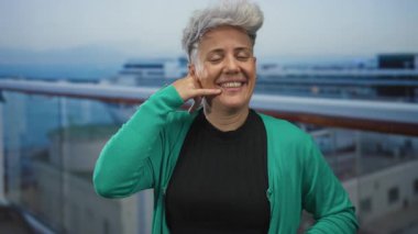 Yeşil kazak giyen kadın, bina üzerinde parmak ile el işareti gösteriyor; oyuncu bağlantı.