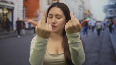 Genç İspanyol kadın, şehrin kalabalık caddelerinin ortasında iki orta parmağını birden gösteriyor..