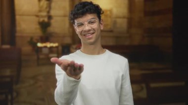 Adam kilise binası koridorunda mum ışığı ve taş duvarlar çerçeveleme sunağı ile aydınlatılmış açık el hareketi sunar;.