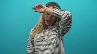 Sarışın orta yaşlı kadın yoğun çabadan sonra parlak bir turkuaz stüdyoda alnından ter silerken;.