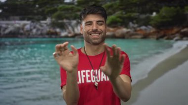 İspanyol cankurtaran el çırpıyor, kırmızı gömlek giyiyor ve güneş ışığı altında tropik sahilde ıslık çalıyor..