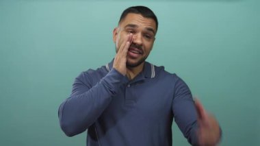 Genç adam canlı bir stüdyoda gülümserken el ele çağırıyor; davet bağlantısı karşılıyor.