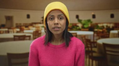 Renkli bir kıyafetin içinde, restoran ortamında, görünürdeki duygu ve günlük tarzıyla şoku ifade eden kadın, şaşırmış tepkisini vurguladı.