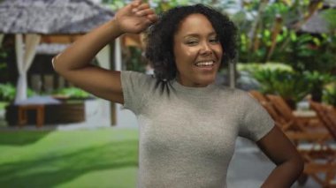 Afrika kökenli Amerikalı kadın otel havuz başı salonu içinde terini eliyle siliyor; rahatlama.