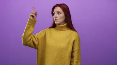 Sarı kazaklı, kırmızı saçlı, mor arkaplanlı, kendine güvenen ve meraklı bir kadın..