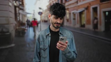 Kot ceketli genç adam şehir sokaklarında neşeli bir şekilde akıllı telefona bakıyor. Heyecanlı ve başarılı, bulanık şehir geçmişi olan..