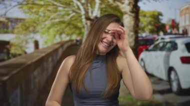 Şehirdeki sonbahar kentsel caddesinde kıt kanaat hareket eden genç beyaz kadın samimi bir ifade sergiliyor;.