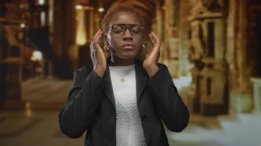 Kadın bardakları ayarlar ve süslemeli taş sütunlar ve kilise içinde vitray pencereler arasında gözlerini kapatır;.