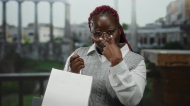 Roma harabelerinin önünde ihtiyatlı bir jest yapan bir kadın Roma 'da alışveriş torbaları tutarken şehrin antik mimarisini neşeli bir ifadeyle sergiliyor..