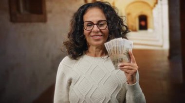 Üniversite ayininin önünde elinde Rus rublesi banknotlarıyla gülümseyen bir kadın ilginç bir finans ve akademi karışımı sergiliyor..