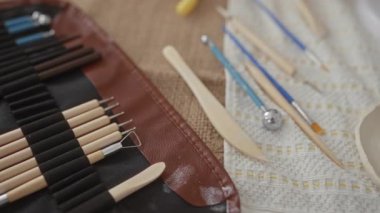 Genç sarışın kadın, sanatsal çömlek atölyesinde çıplak elle yumuşak çamur şekillendiriyor; yaratıcılık odaklı sanatçılık.