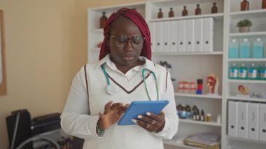 Klinikte steteskop takan kadının boynu ağrıyor gibi görünüyor. Tıbbi malzemeler ve raflarla çevrili..