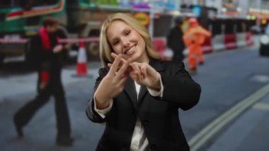 İnşaat alanında gülümseyen bir kadın, arka planda çalışan insanlarla birlikte şehir caddesinde siyah kıyafetler giydiğini gösteren hashtag hareketi gösteriyor..