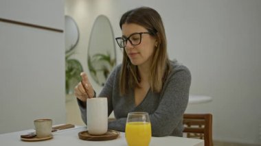 Modern kafede içki içen bir kadın gözlüklü ve süveterli şık dekorlu ve şık bir atmosferle çevrili..