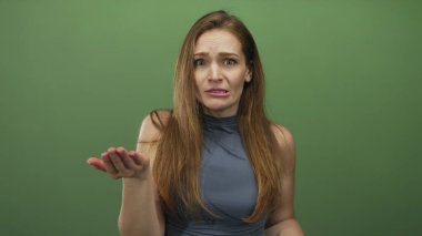 Avuç içi açık yalvaran ve yeşil stüdyo ortamında yüz ifadesini savunan beyaz bir kadın, çaresizlik savunması..
