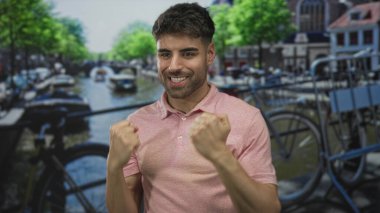 Erkekler sıkılmış yumruklarını kaldırıyor ve bisiklet ve binaların arasında kanalda gülümsüyor; sevinç zaferi kutlamaları.