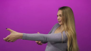 Stüdyoda izole edilmiş hayali bir halatı çeken genç bir kadın oyuncu etkileşimi ve egzersiz konseptini sergiliyor..