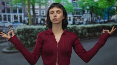 Elleri birbirine bastırılmış ve avuçları sokakta büyümüş genç İspanyol kadın; huzur meditasyonu yansıması.