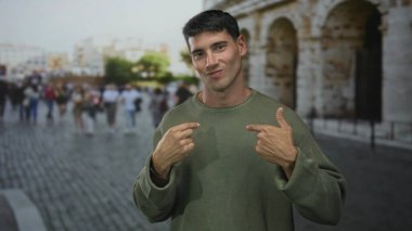 Antik Roma kolezyum binasının yakınındaki güneş ışığı sokağında, yeşil kazaklı genç adam, reddediyor..