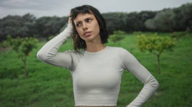 Genç İspanyol kadın yeşil bir orman bahçesinde el ele tutuşuyor görünür ağaçlar ve çimenler genişliyor..