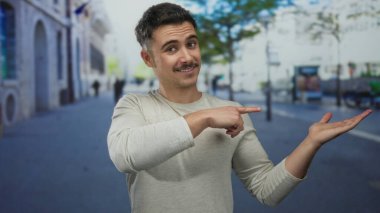 Genç İspanyol bir adam, şehir sokaklarında iyi niyetli bir jest yaparak şehir ortamında pozitif ve konuşkan bir ruh hali içinde olduğunu gösteriyor..