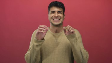 Erkek omuzlarını kaldırır ve arka planda süveter çekerken İspanyol genç erkek gergin ve gergin görünür..