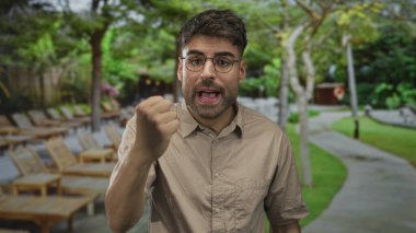 İnsan açık havuz tesisinde güneşlenirken yumruğunu ağzının yanında tutar; azim kararlılığı çözer.