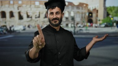 İspanyol şef işaret ediyor. Hayır, Roma 'nın kolezyumunun önünde, siyah üniforma giyiyor, canlı bir şehir manzarasında duruyor, aşçılık sanatını tarihi mimariyle harmanlıyor..