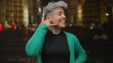 Kadın el telefonu jesti dekoratif kilise içinde ahşap banklar odaklı iç yapı; dostça iletişim bağlantısı.