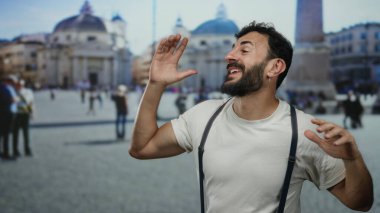 Sakallı İspanyol bir adam, açık havada gülümsüyor, sokak ortamında beyaz gömlek giyiyor, bulanık tarihi mimariye karşı canlı bir etkileşim içinde.