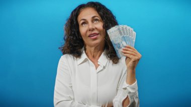 Şili banknotlarını mavi arka planda tutan bir kadın orta yaş ve finansal başarı sergiliyor kendine güvenen bir gülümsemeyle..