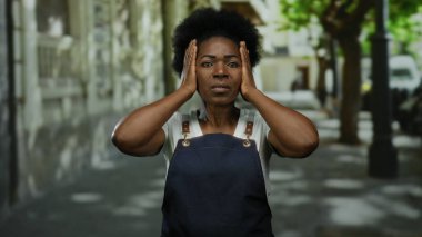 Önlük giyen kadın, şehir sokaklarında elleri sıcak, şehir yaşamını somutlaştıran, çeşitli hisse senedi imajları için duyguları somutlaştıran bir şekilde duruyor..