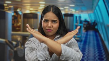 Motivasyonel ambiyansı olan bir spor salonundaki hoşnutsuzluğunu ifade eden genç bir kadın, kişisel fitness hedefleri için kapalı spor merkezi ortamındaki kararlılığını sergiliyor..