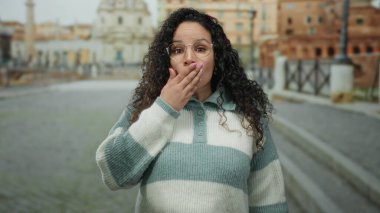 Roma harabelerinde duygularını ifade eden kadın, arka planda gündüz vakti antik mimariyle birlikte caddeyi yıkıyor..