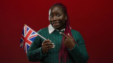 Kızıl arka planda Birleşik Krallık bayrağını tutan örgü örgülü bir kadın, İngiltere 'de ulusal gururunu sergileyen Afrikalı bir Amerikalı var..